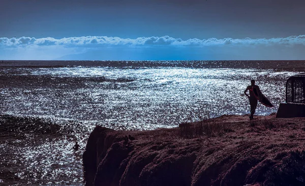 2013年1月27日 美国圣克鲁斯 当这位冲浪运动员抱着木板站在岩石上的时候 看着圣塔芭芭拉湾的日落 — 图库照片