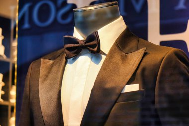 The Hague, Netherlands - January 03 2022: a shiny and elegant tuxedo and black tie are on display on a doll in a shop window of a store during the holiday season