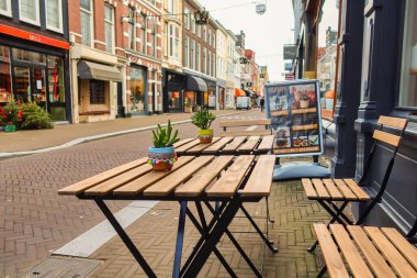 The Hague, Netherlands - January 03 2022: the terrace of a small restaurant in a typical historic dutch street with table and chairs
