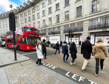 Londra, Birleşik Krallık - 6 Mart 2022: İnsanlar Viktorya dönemi binaları ve tipik İngiliz otobüsleriyle ünlü kral naibi caddesinde alışveriş yapıyorlar.