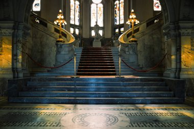 The Hague, Netherlands - April 21 2022 : elegant stairs with red carpet inside the famous peace palace of royal class