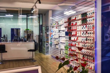 Lahey, Hollanda - 03 Ocak 2022: Bir telekomünikasyon mağazasında telefon kılıfları duvarda asılı durumda ve tamirat da dahil olmak üzere akıllı telefon için her türlü ürünü satıyorlar.