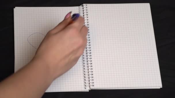 Menina risca um coração e desenha um dólar em um caderno — Vídeo de Stock