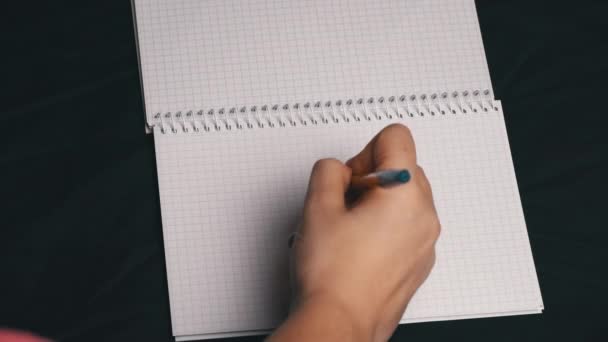 Chica dibuja un corazón y rasga una página de un cuaderno — Vídeo de stock