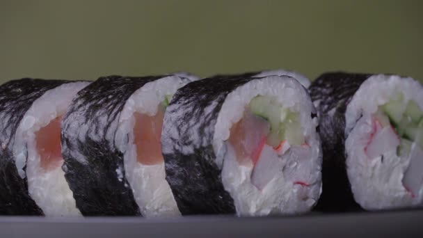 Sushi Roll girou em um fundo verde. — Vídeo de Stock