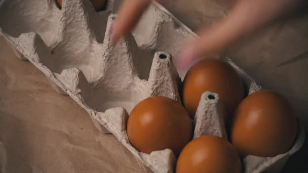 Mão das mulheres tira um ovo de galinha de um recipiente — Vídeo de Stock