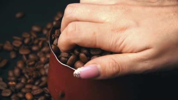Γυναικείο χέρι σκορπίζει καβουρδισμένο καφέ φασόλια με ένα Cezve — Αρχείο Βίντεο