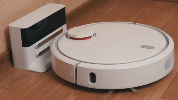 白色机器人吸尘器完成清洗并驱动至充电站 — 图库视频影像