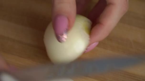 Κορίτσι με ένα όμορφο μανικιούρ κόβει ένα κρεμμύδι — Αρχείο Βίντεο