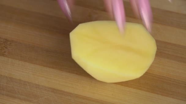 Menina com uma bela manicure corta uma batata — Vídeo de Stock