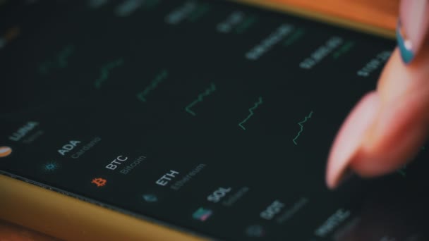 Mão de uma garota comerciante toca a exibição de cotações do mercado de ações em um smartphone — Vídeo de Stock