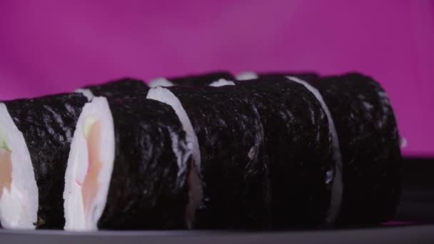 Sushi Roll Turned on a Pink Background — Stock Video