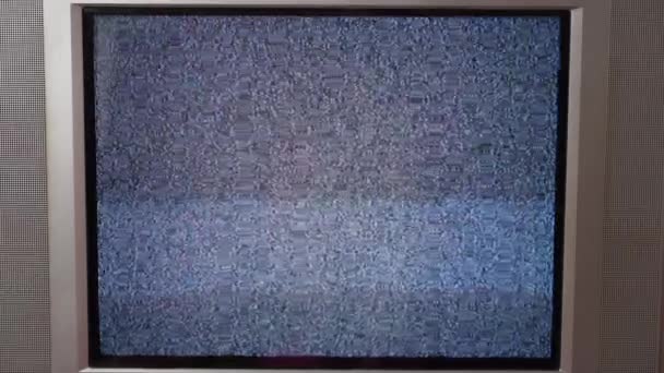 Flicka byter kanal på en gammal TV med buller — Stockvideo