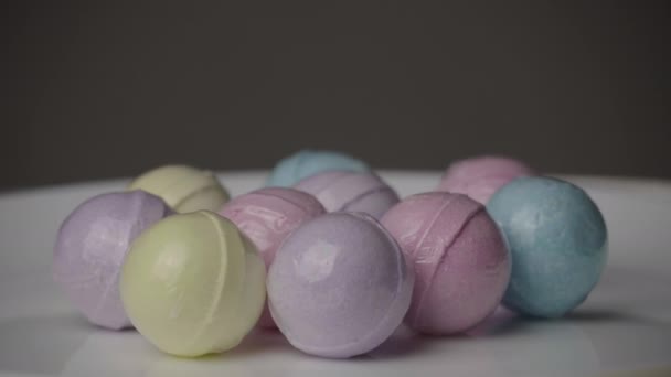 Bath Bombs in Different Colors Spin Against a Black Background. — Stockvideo