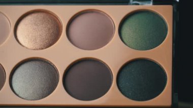 Kız eliyle göz gölgesini alır.