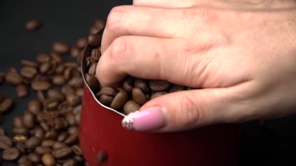 Hembra dispersa granos de café tostados con un Cezve — Vídeo de stock