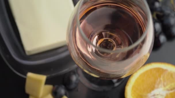 Ein Glas Ros Wein wirbelt mit Vorspeisen — Stockvideo