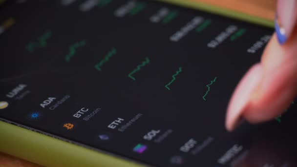 Mão de uma garota comerciante toca a exibição de cotações do mercado de ações em um smartphone — Vídeo de Stock