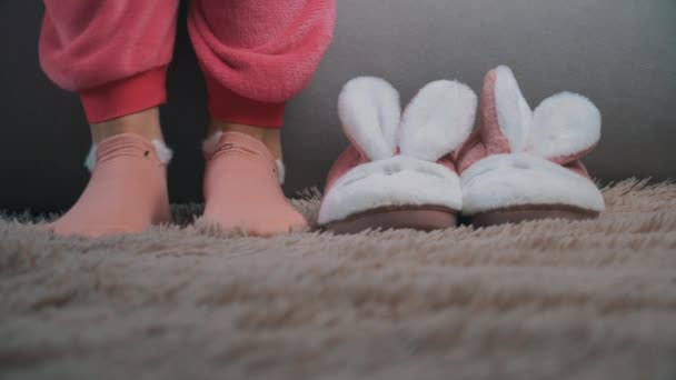 Fiatal nő felkel az ágyból, és reggel rózsaszín papucsot vesz fel — Stock videók