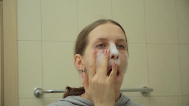 Menina bonita esfrega uma máscara em seu rosto — Vídeo de Stock