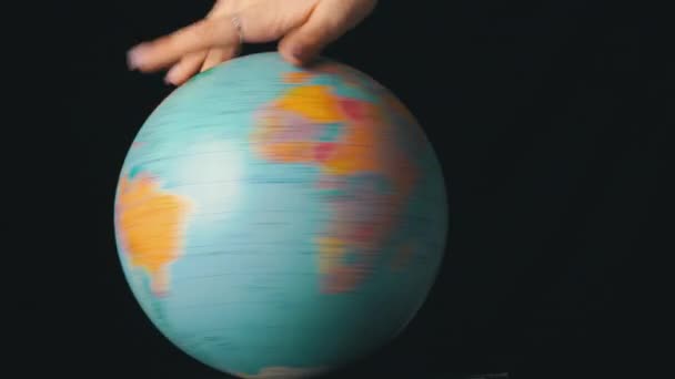 Geografisk glob vrids runt sin axel av en kvinnlig hand — Stockvideo