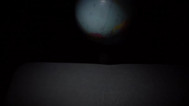 Geografiska Globen rullar på en svart yta i Slowmo — Stockvideo