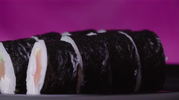 Sushi Roll Turned on a Pink Background — Stock Video