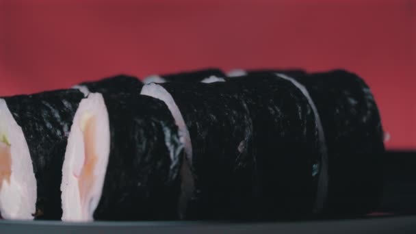Sushi Roll girou em um fundo vermelho. — Vídeo de Stock