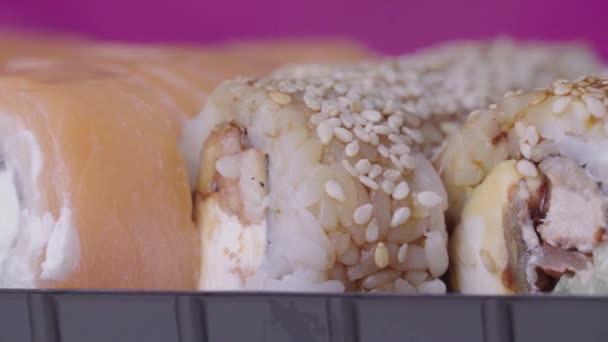 Sushi tekercs bekapcsolt egy rózsaszín háttér — Stock videók