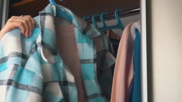 Дівчина вибирає речі в гардеробі вдома — стокове відео