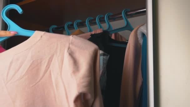 Chica elige cosas en el armario en casa — Vídeo de stock