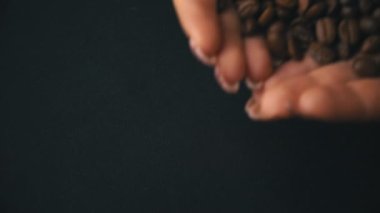 Kahve çekirdekleri kadın ellerinden sarkıyor.