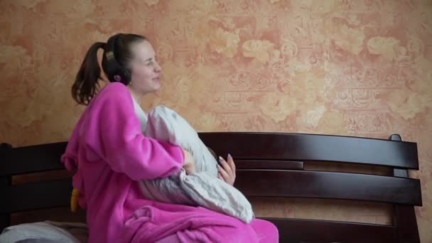 Girl in Pyjamas on the Bed Écoute de la musique avec des écouteurs et des danses Slowmo — Video