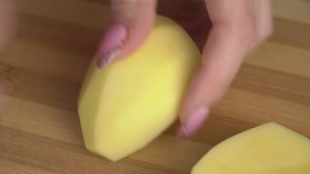 Κορίτσι με ένα όμορφο μανικιούρ κόβει μια πατάτα — Αρχείο Βίντεο