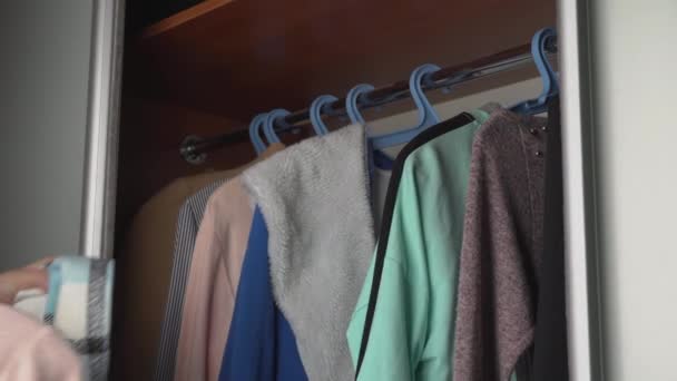 Девушка выбирает вещи в гардеробе — стоковое видео