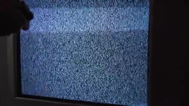 Дівчина змінює канали на старому телевізорі з шумом — стокове відео