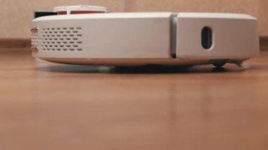 Beyaz Robotik Elektrikli Süpürge Temizleyicisi Temizliği bitirdi ve Şarj İstasyonuna Sürüyor