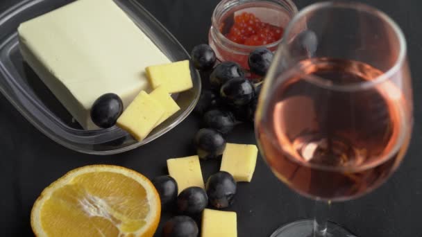 Dziewczyna bierze winogrona na tle szklanki wina i przekąski — Wideo stockowe