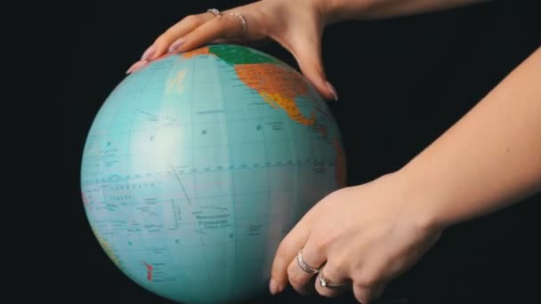 Zeměpisný glóbus se kroutí kolem své osy ženskou rukou — Stock video