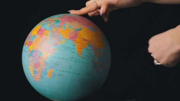 Földrajzi Globe csavarodott körül tengelye egy női kéz — Stock videók