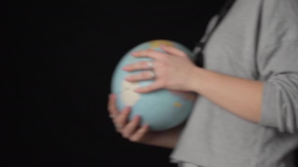 Meisjes handen Draai de geografische bol rond zijn as — Stockvideo