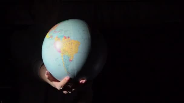 Meisjes handen Draai de geografische bol rond zijn as — Stockvideo