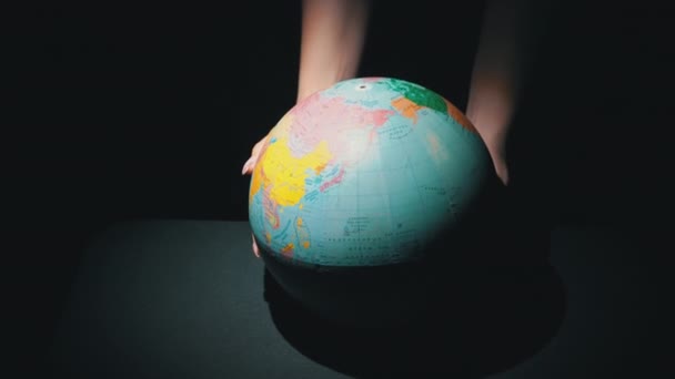 Meisjes handen Draai de geografische bol rond zijn as — Stockvideo