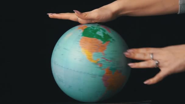 Földrajzi Globe csavarodott körül tengelye egy női kéz — Stock videók