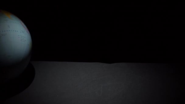 Zeměpisný globus se válí na černém povrchu ve Slowmu — Stock video