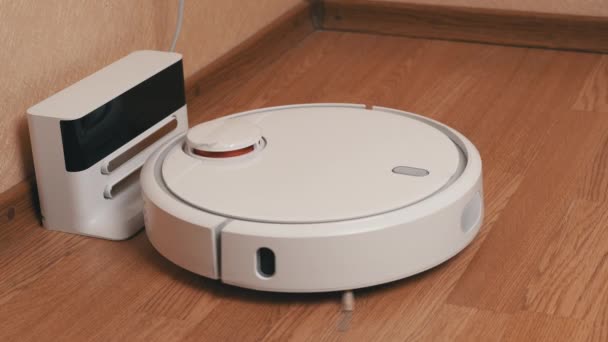 White Robotic Vacuum Cleaner Finishes Cleaning And Drives to Its Charging Station — Stok Video