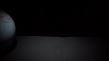 Coğrafi Küre Slowmo 'da Siyah Yüzeyde Yuvarlanıyor