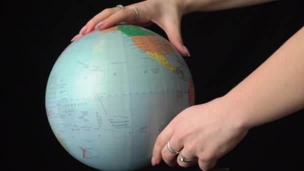 Globo geográfico es retorcido alrededor de su eje por una mano femenina — Vídeos de Stock