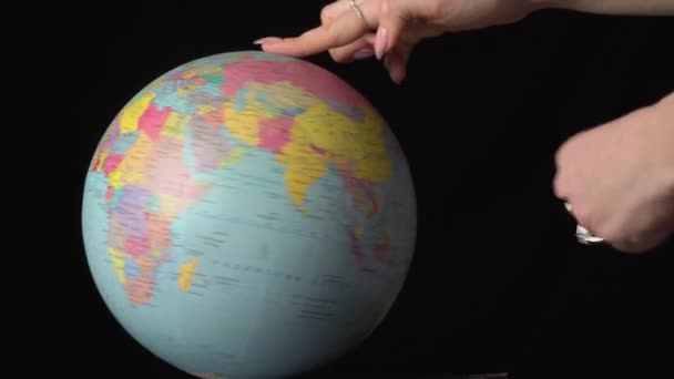 Globo geográfico es retorcido alrededor de su eje por una mano femenina — Vídeos de Stock