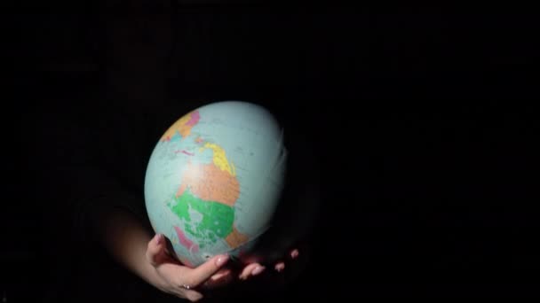 Meisjes handen Draai de geografische bol rond zijn as — Stockvideo